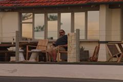 Finchy enjoying a red and the sunset at the Seawall apartments at Glenelg